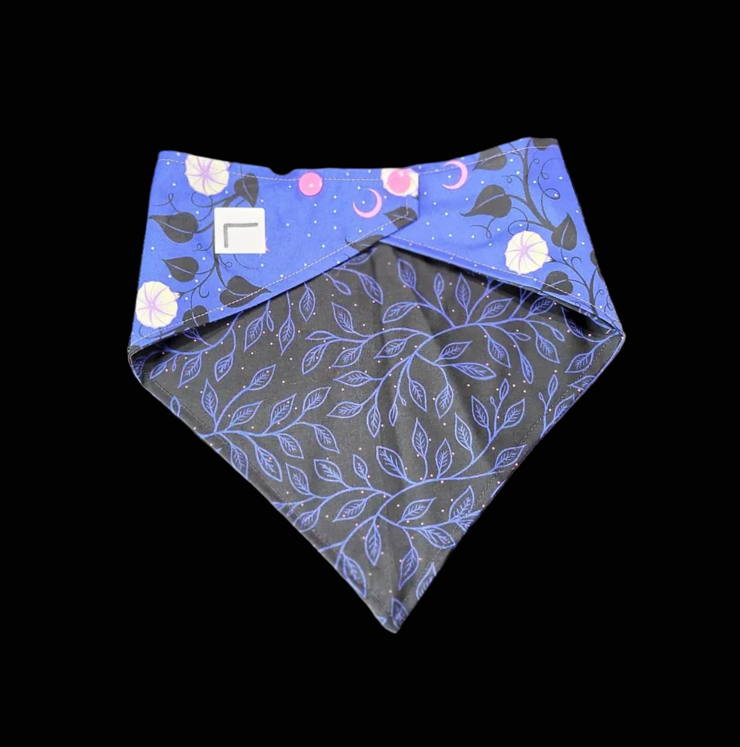 Two fabric swatches with floral and leaf patterns on a dark surface