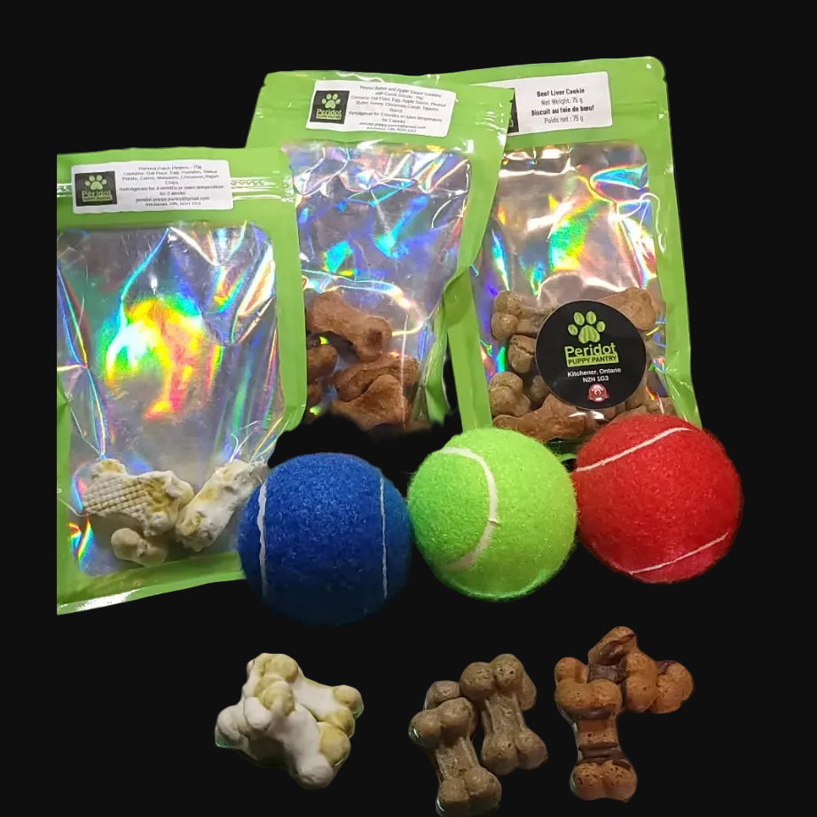 Dog treats, toys, and packaging on a black surface