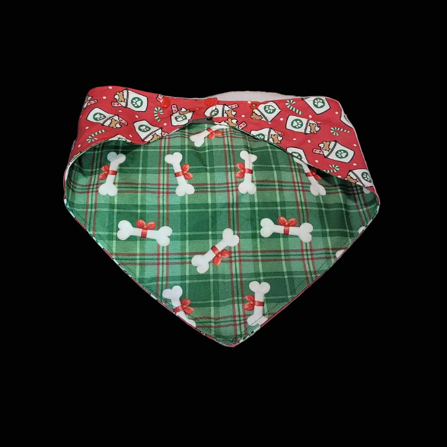 Two dog bandanas on a wooden surface, one red with white patterns and the other green with white patterns.
