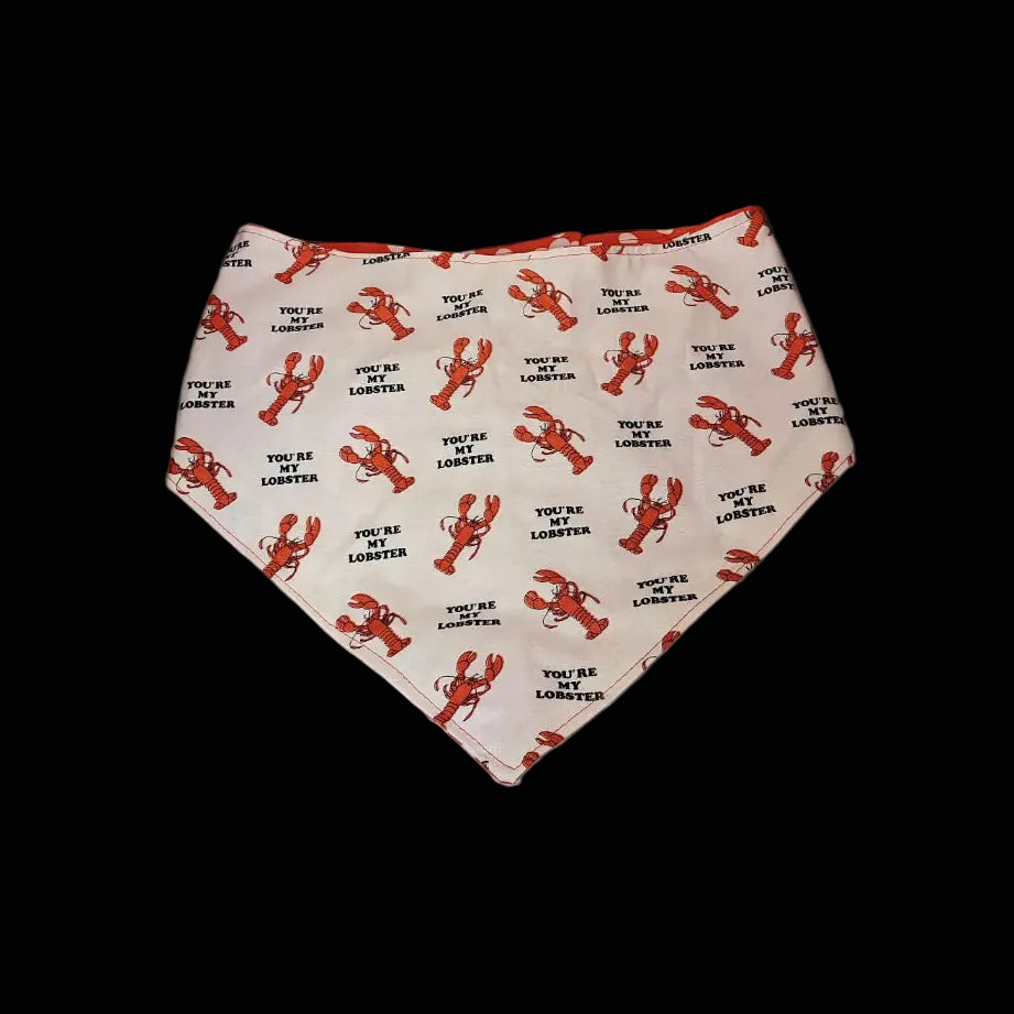 Dog bandana with lobster pattern on a wooden surface