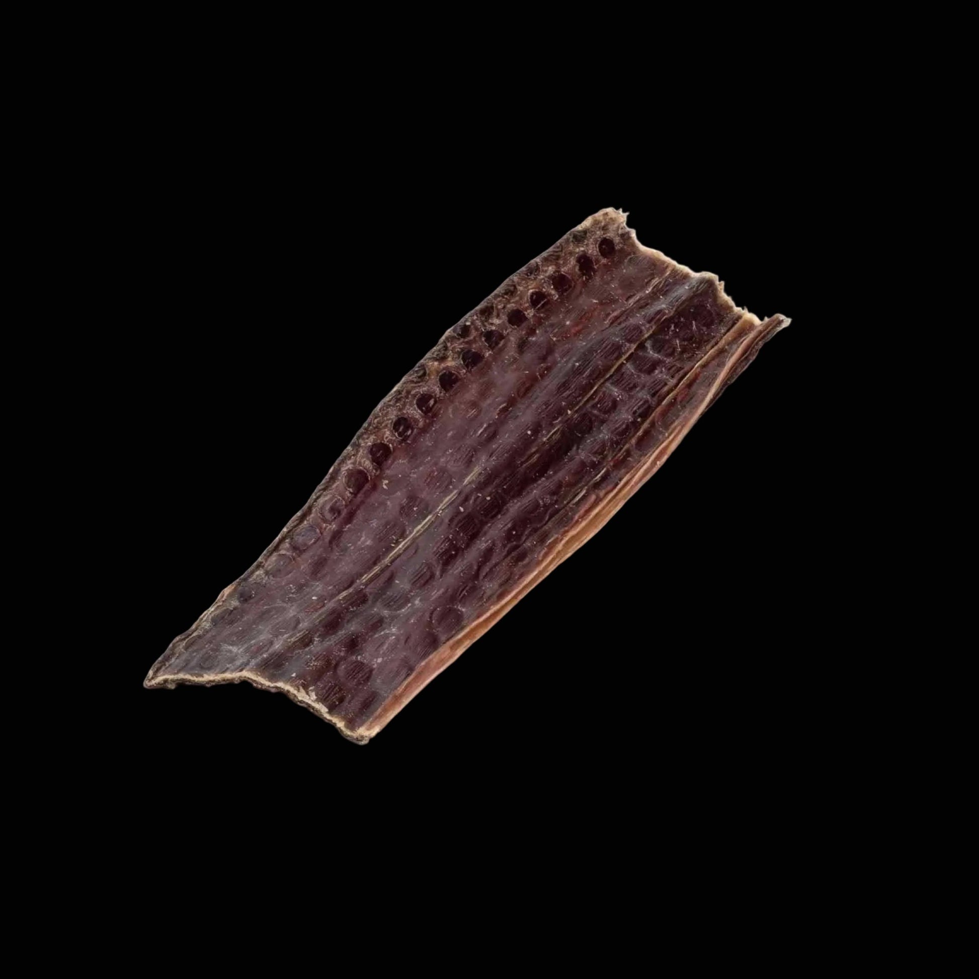 Dried brown beef jerky on black background