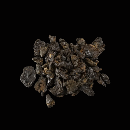 Pile of dark brown dried chicken hearts on black background