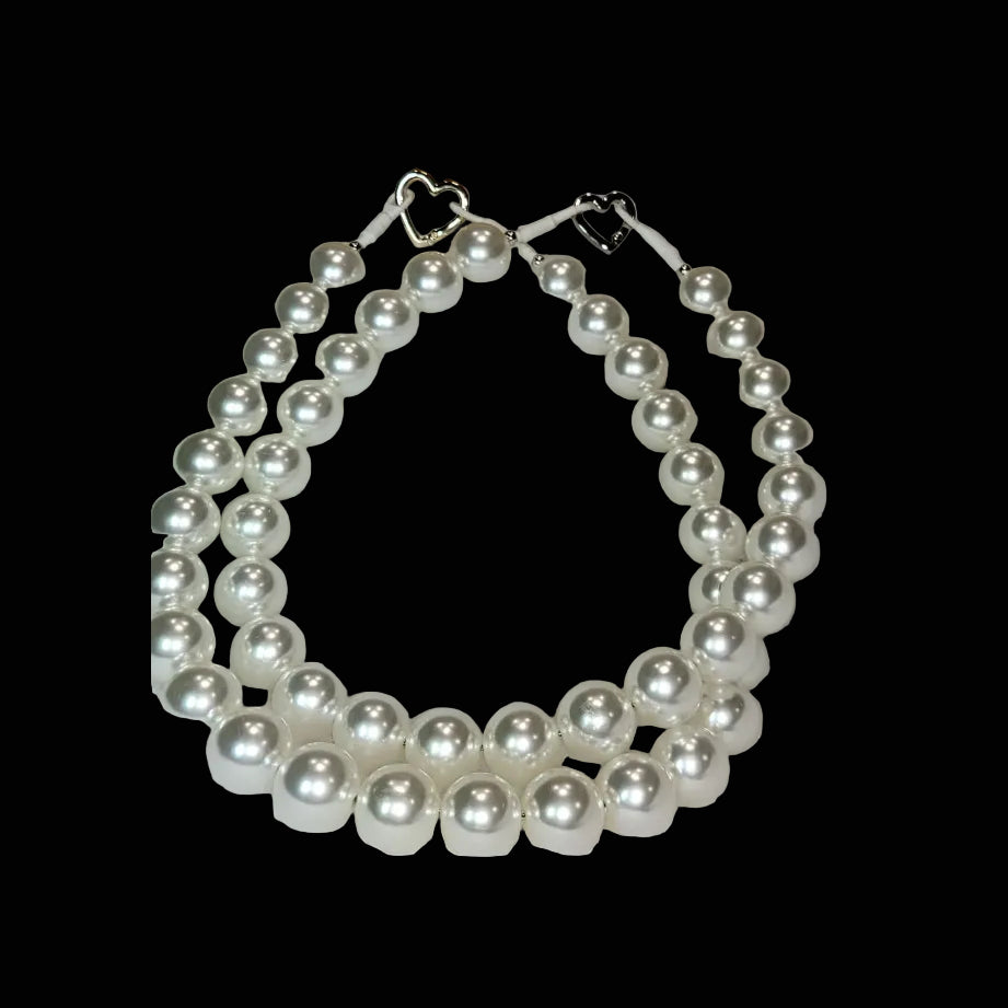 Pearl necklace on a white surface with a wooden background