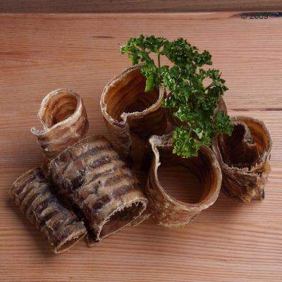 Rolled-up bread sticks with a sprig of parsley on a wooden surface