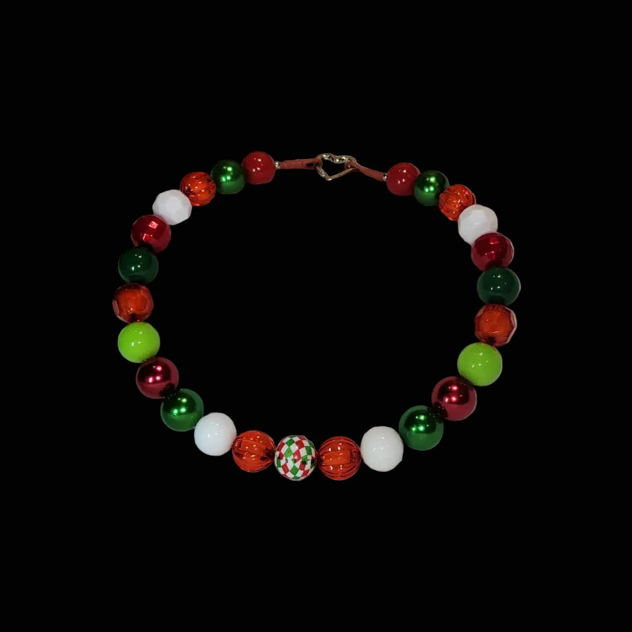 Necklace with multicolored beads on a white surface with wooden background