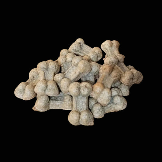 Small pile of beige dog treats on a black surface