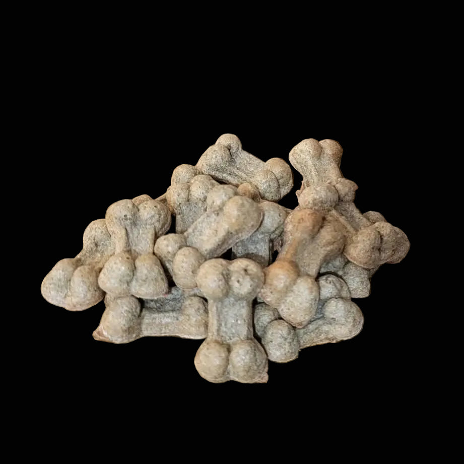 Small pile of beige dog treats on a wooden surface