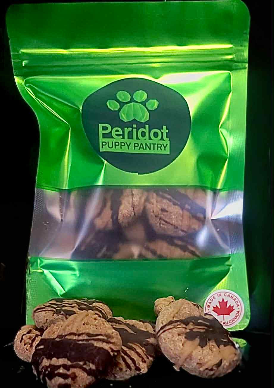 Green package of Peridot Puppy Pantry with dog treats on a black background